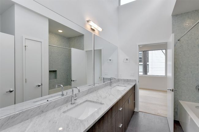 Full bath featuring a tub to relax in, a sink, and tile patterned flooring | Image 18