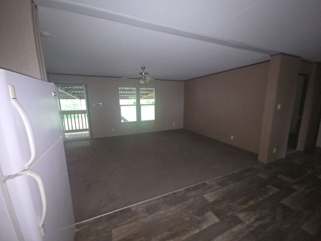Empty room featuring ceiling fan and wood finished floors | Image 8