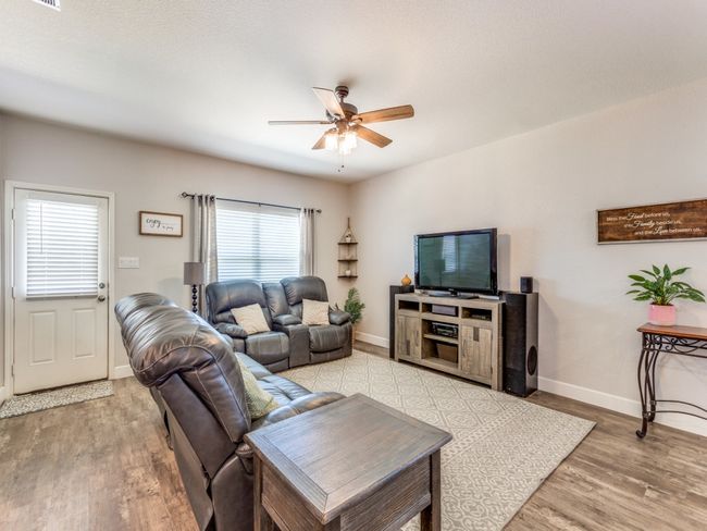 Living area with ceiling fan and light wood-style flooring | Image 6