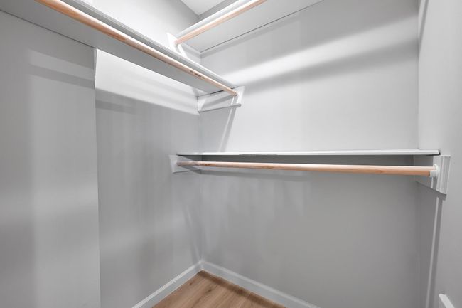 Walk-in closet with double rods – Ample space and built-in shelving. | Image 31