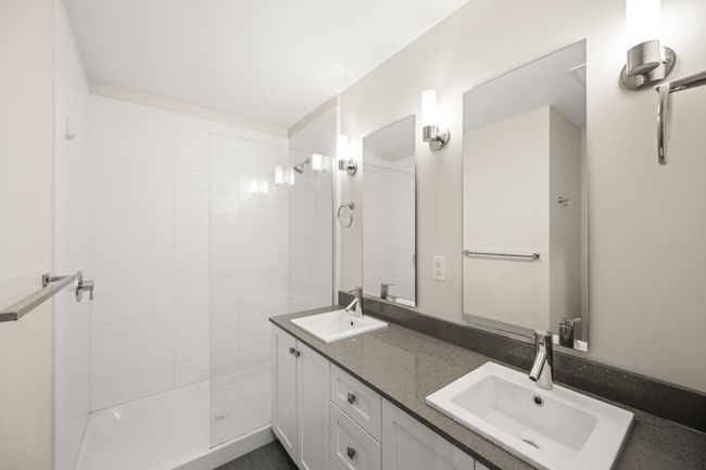 Full bathroom featuring double vanity and a tile shower | Image 17