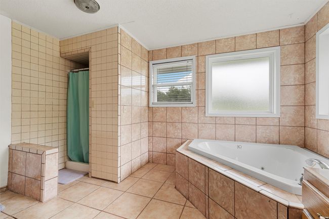 Bathroom with a whirlpool tub, tile walls, tile patterned floors, and a tile shower | Image 21