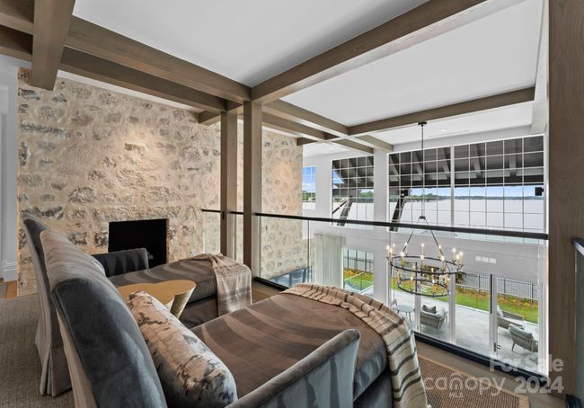 Open to the Grand Salon and Foyer below. This cozy loft features lake views and a fireplace. | Image 26