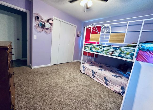 Bedroom with a closet, carpet floors, ceiling fan, baseboards, and a textured ceiling | Image 17