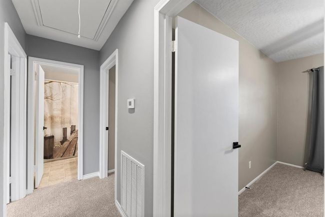 This photo shows a hallway with several doors leading to different rooms. | Image 19