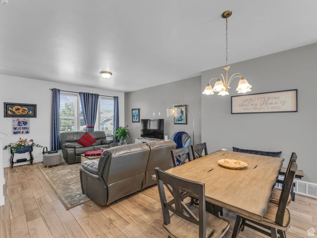 Dining space with light wood-style flooring and a chandelier | Image 13