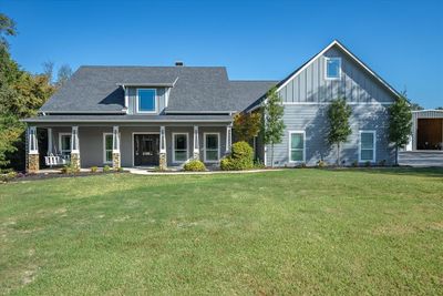 View of front of property featuring a front yard and large covered porch with hanging swing | Image 3