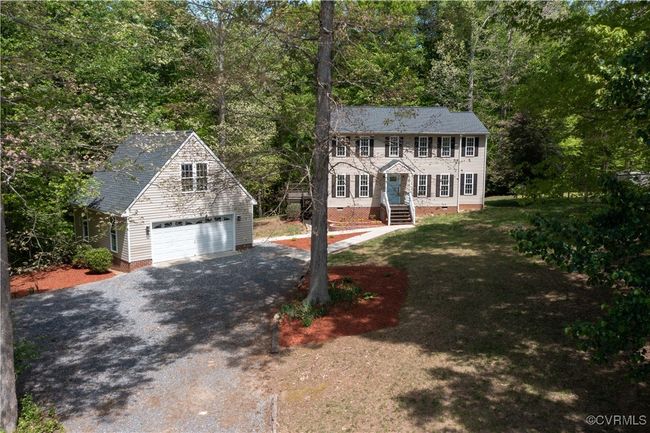 Colonial home with crawl space, a wooded view, driveway, an outdoor structure, and a garage | Image 38