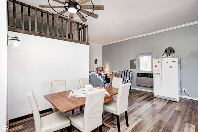 dining space with baseboards, electric panel, crown molding, ceiling fan, and wood finished floors | Image 53