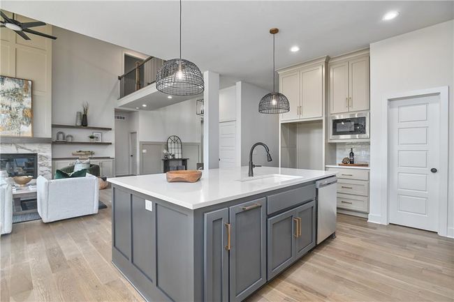 Kitchen with appliances with stainless steel finishes, light wood-type flooring, sink, and gray cabinetry | Image 17