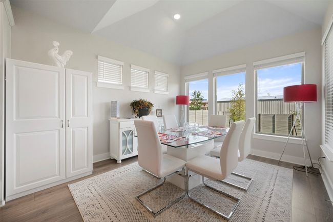 Dining area with lofted ceiling and wood finished floors | Image 22
