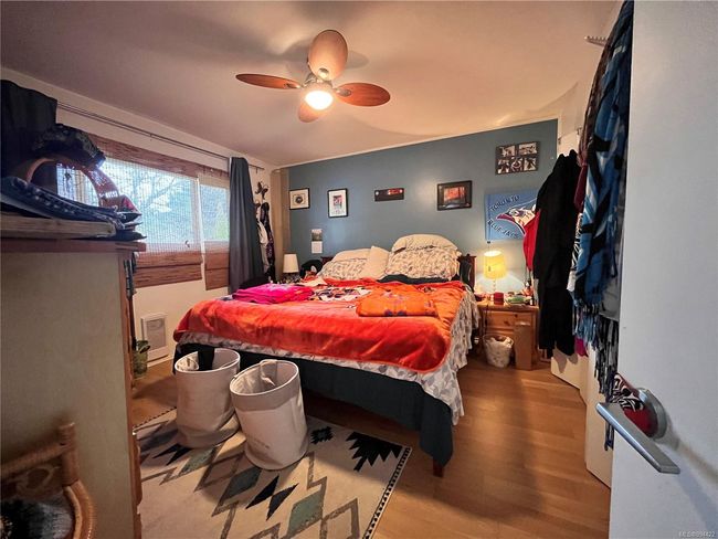 Bedroom with a ceiling fan and wood finished floors | Image 12