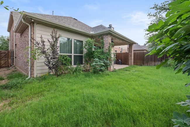 Rear view of house with brick siding, a fenced backyard, a ceiling fan, and roof with shingles | Image 29