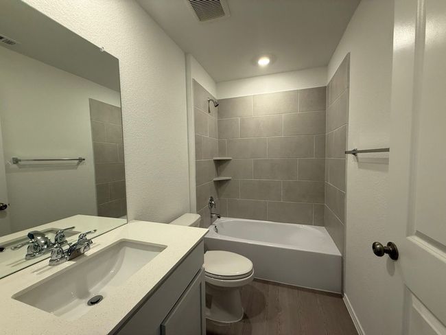 Full bath featuring wood finished floors, vanity, toilet, shower combination, and recessed lighting | Image 12