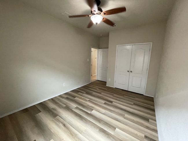 Unfurnished bedroom featuring wood finished floors, a closet, and ceiling fan | Image 23