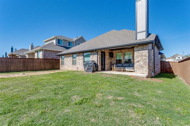 Back of property with a fenced backyard, brick siding, an outdoor living space, and a yard | Image 5