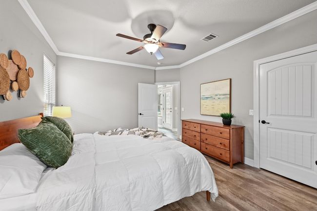 Bedroom featuring ornamental molding, wood-like finished floors, multiple windows, and ceiling fan | Image 18