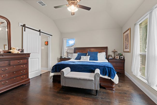 Bedroom with a barn door, lofted ceiling, dark wood finished floors, and ceiling fan | Image 15