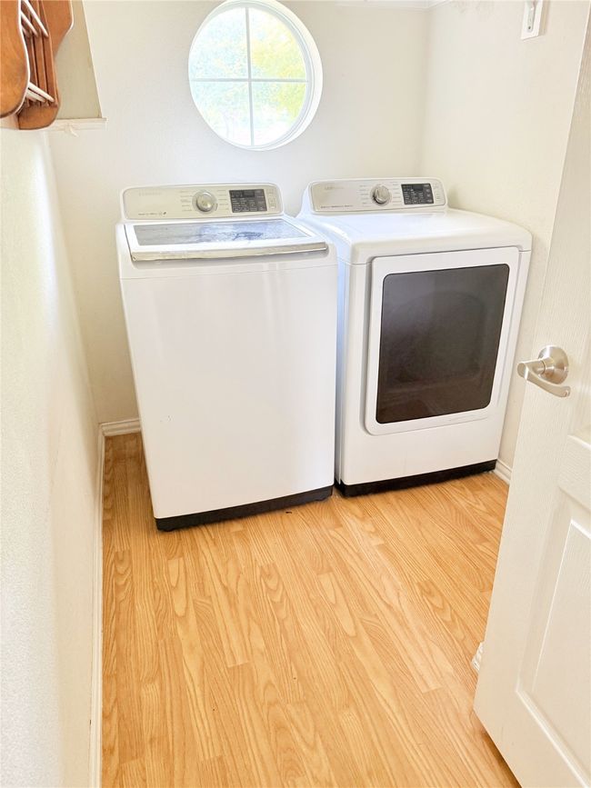 Laundry room with washer and dryer and wood finished floors | Image 16