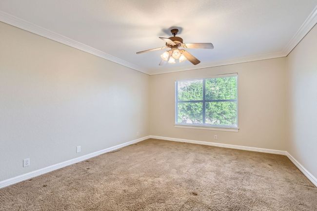 Spare room with a ceiling fan, baseboards, ornamental molding, and carpet floors | Image 27
