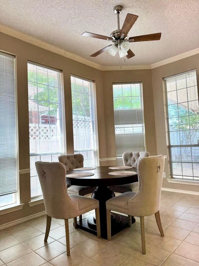 Dining space featuring a wealth of natural light, light tile patterned floors, a textured ceiling, and a ceiling fan | Image 4