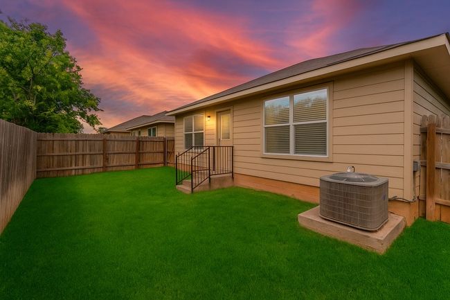 Back of house at dusk featuring a fenced backyard | Image 23