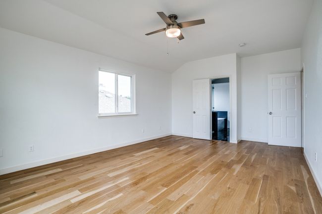 Unfurnished bedroom featuring light wood finished floors, baseboards, vaulted ceiling, and a ceiling fan | Image 28