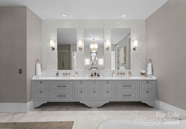 Stunning marble countertops, wall mounted fixtures, custom cabinetry, ample storage, and beautiful sconces. | Image 20