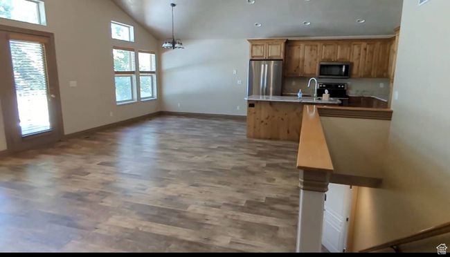 Kitchen with stainless steel appliances, wood finished floors, baseboards, pendant lighting, and a peninsula | Image 16