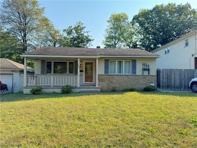 View of front of home with a garage, a porch, and a front yard | Image 1