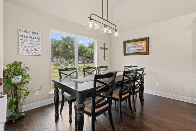 Dining space with dark wood-type flooring and lofted ceiling | Image 23