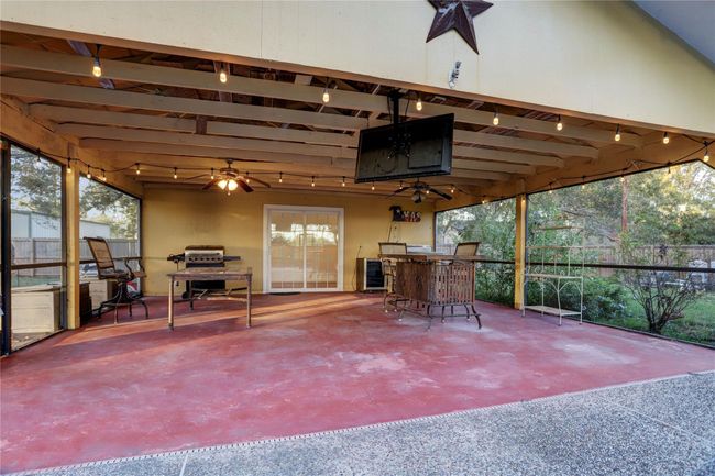 COVERED POOL PATIO WITH T.V., BBQ PITS, TABLES, CHAIRS, WINE COOLER, LIGHTS, SINK W/FAUCET & COUNTER TO CLEAN FISH, ETC. PERFECT SETTING FOR A POOL PARTY!! - PATIO LEADS TO GUEST HOUSE! | Image 25