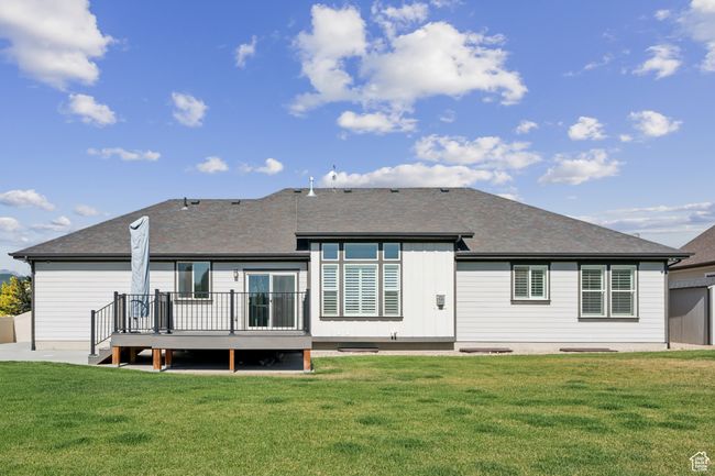 Rear view of property featuring a deck, a lawn, and roof with shingles | Image 36