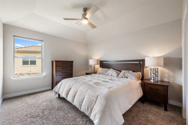 Bedroom with carpet flooring, ceiling fan, and lofted ceiling | Image 25