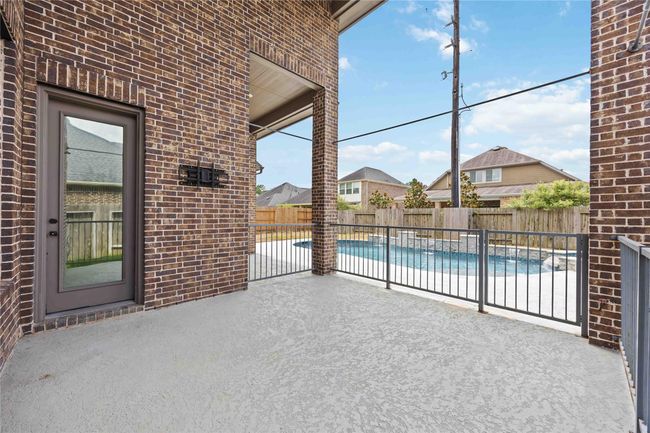 Cozy patio with brick walls, leading to a backyard swimming pool. The area is fenced for privacy and safety, especially if you have children. Perfect spot for relaxation and outdoor entertainment. | Image 41