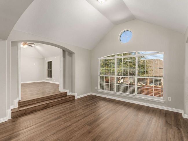 Unfurnished room featuring baseboards, wood finished floors, and vaulted ceiling | Image 25
