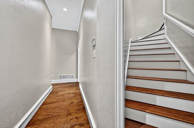 Stairs featuring wood finished floors, a textured wall, recessed lighting, and baseboards | Image 28