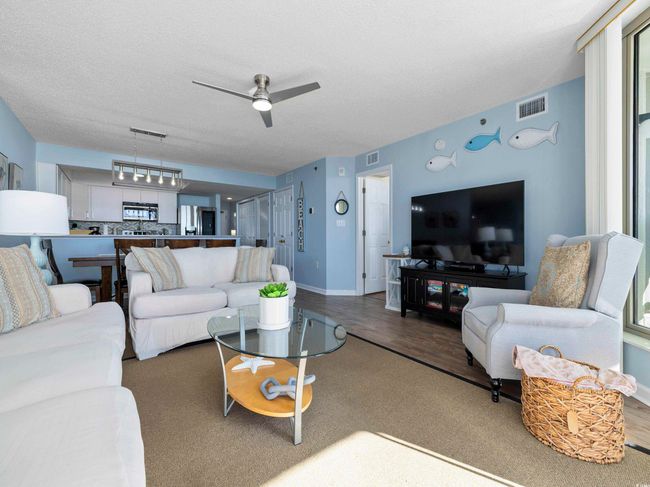 Living room featuring wood finished floors, a ceiling fan, visible vents, and a textured ceiling | Image 6