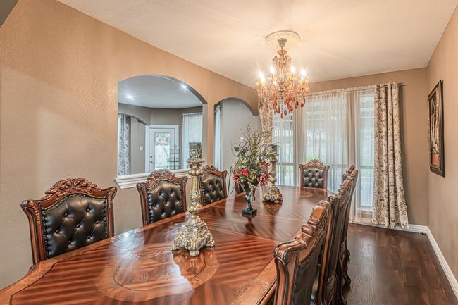 Dining area with arched walkways, a chandelier, and dark wood-type flooring | Image 15