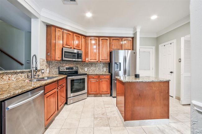 Spacious kitchen features granite countertops and stainlesss appliances. | Image 7