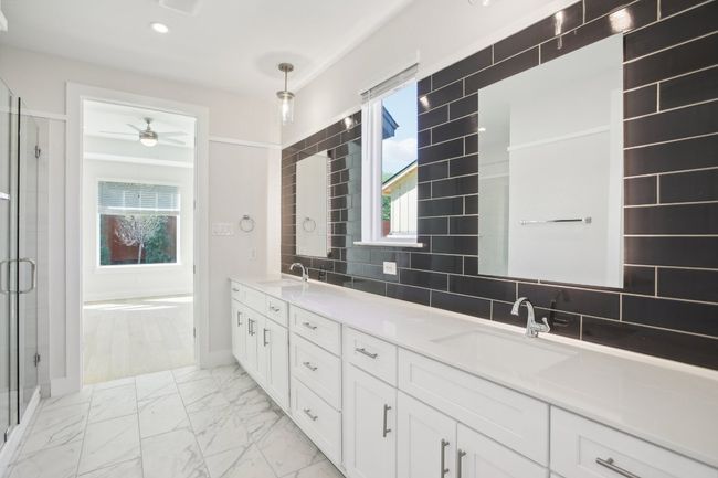 Full bathroom with a stall shower, decorative backsplash, marble finish floor, a sink, and ceiling fan | Image 22