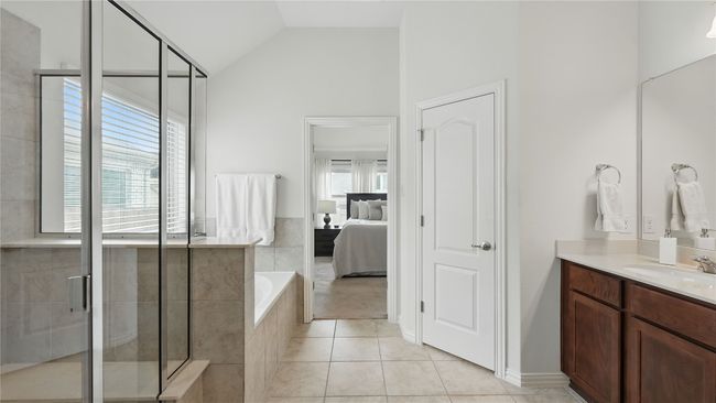 Ensuite bathroom with vanity, a bath, a shower stall, tile patterned flooring, and lofted ceiling | Image 26