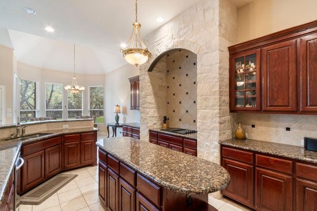 Kitchen featuring a sink, a chandelier, decorative backsplash, black electric cooktop, and recessed lighting | Image 17