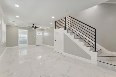 MID-LEVEL DINING AREA LOOKING TOWARDS FRONT DOOR INTO DEN AND SUNROOM WITH BEAUTIFUL TILED FLOORS, RECESSED LIGHTING, CROWN MOULDING | Image 3