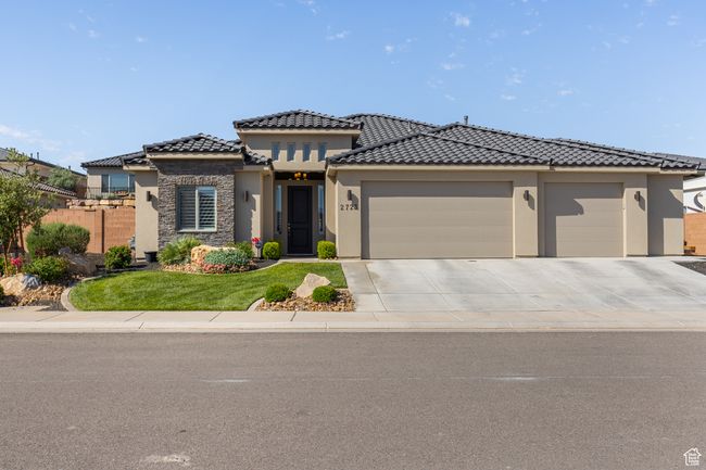 View of front of home featuring stucco siding, an attached garage, a tile roof, and driveway | Image 62