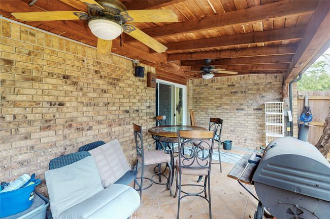 View of patio featuring ceiling fan, outdoor dining area, and grilling area | Image 16
