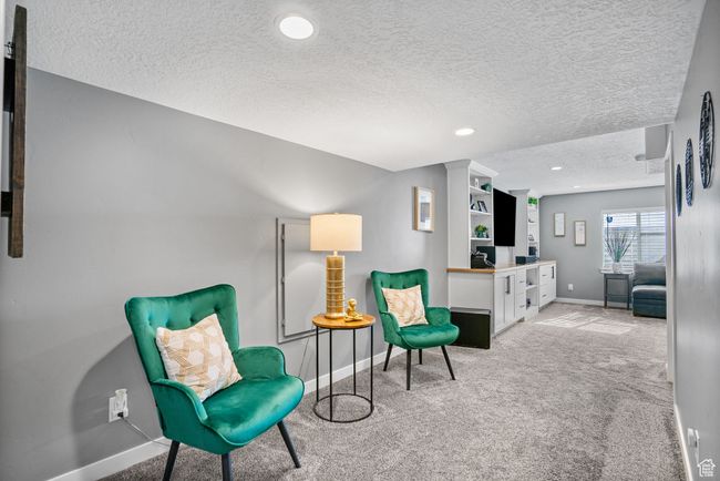 Living area with light colored carpet, baseboards, a textured ceiling, and recessed lighting | Image 23