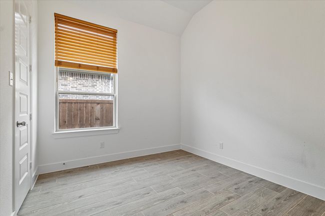 Spare room featuring baseboards, light wood-style flooring, and lofted ceiling | Image 20