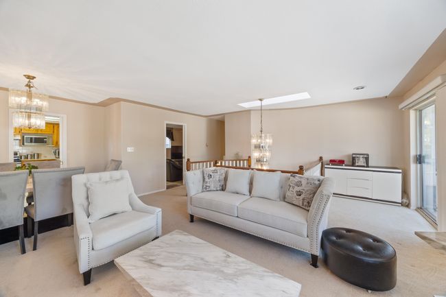 Living room featuring light colored carpet and a chandelier | Image 11