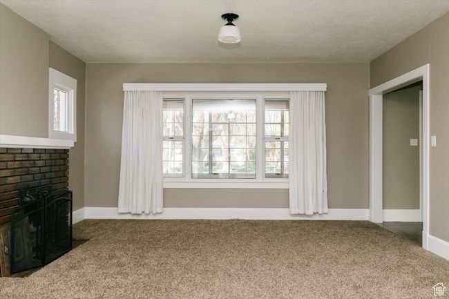 Empty room with baseboards, visible vents, wood finished floors, and a textured ceiling | Image 4